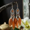 S97d23d383a1a4f409b4ad8726948c3a1Z.webp Boho Feather Earrings with Vibrant Gemstone Accents