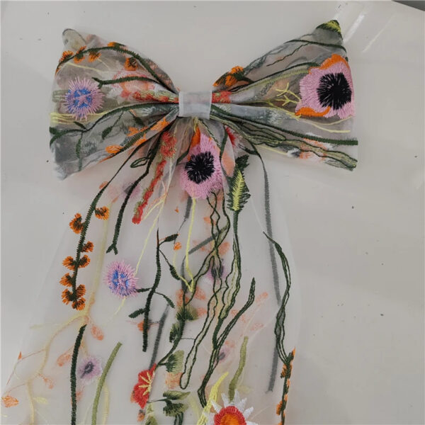 3 The Poppy Bow, a wildflower embroidered wedding hair bow with veil tails on a comb