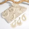 S0d20398053804a6680863278c33d56ccK.webp Textured raffia statement earrings styled as a woven trio