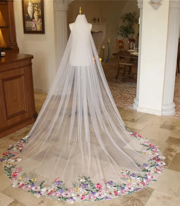 The Bellflower Veil, a cathedral wedding veil with three-dimensional embroidered wildflowers along the hem