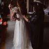 Back of a simple organza A-line wedding dress being fastened before the ceremony