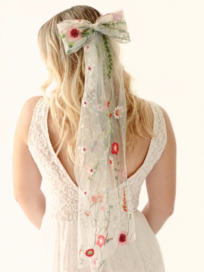 The Poppy Bow, a wildflower embroidered wedding hair bow with veil tails on a comb