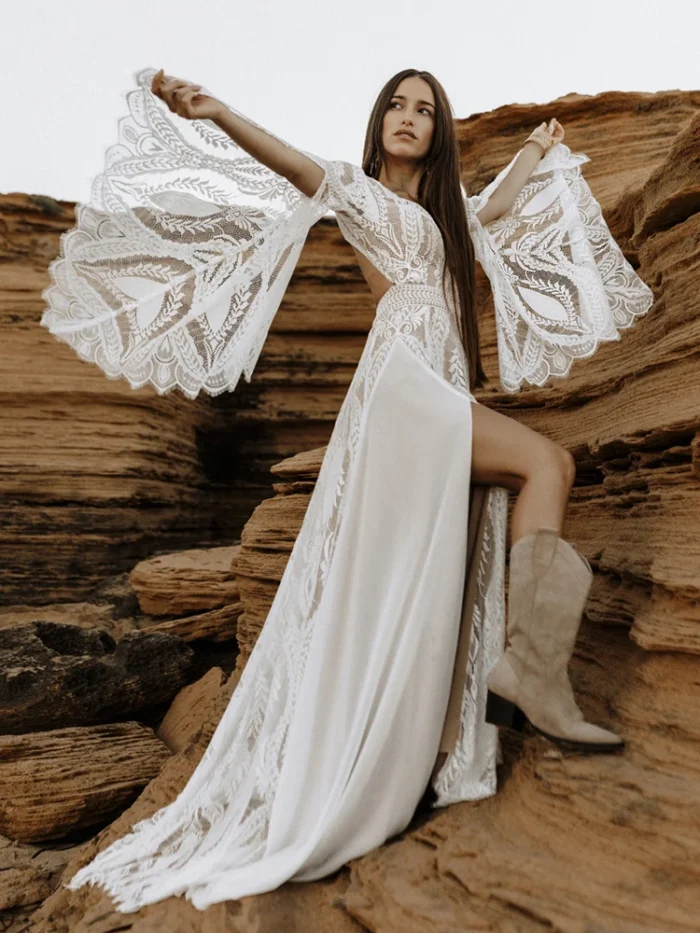 Full-length front view of boho lace wedding dress with split bell sleeves and front slit