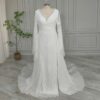 Off-white lace wedding gown with bell sleeves and flowing skirt