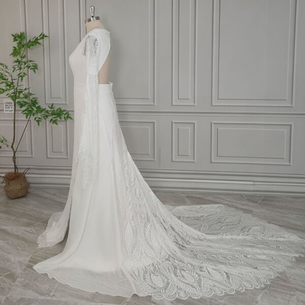 Side rear view of open-back lace wedding gown with flowing train